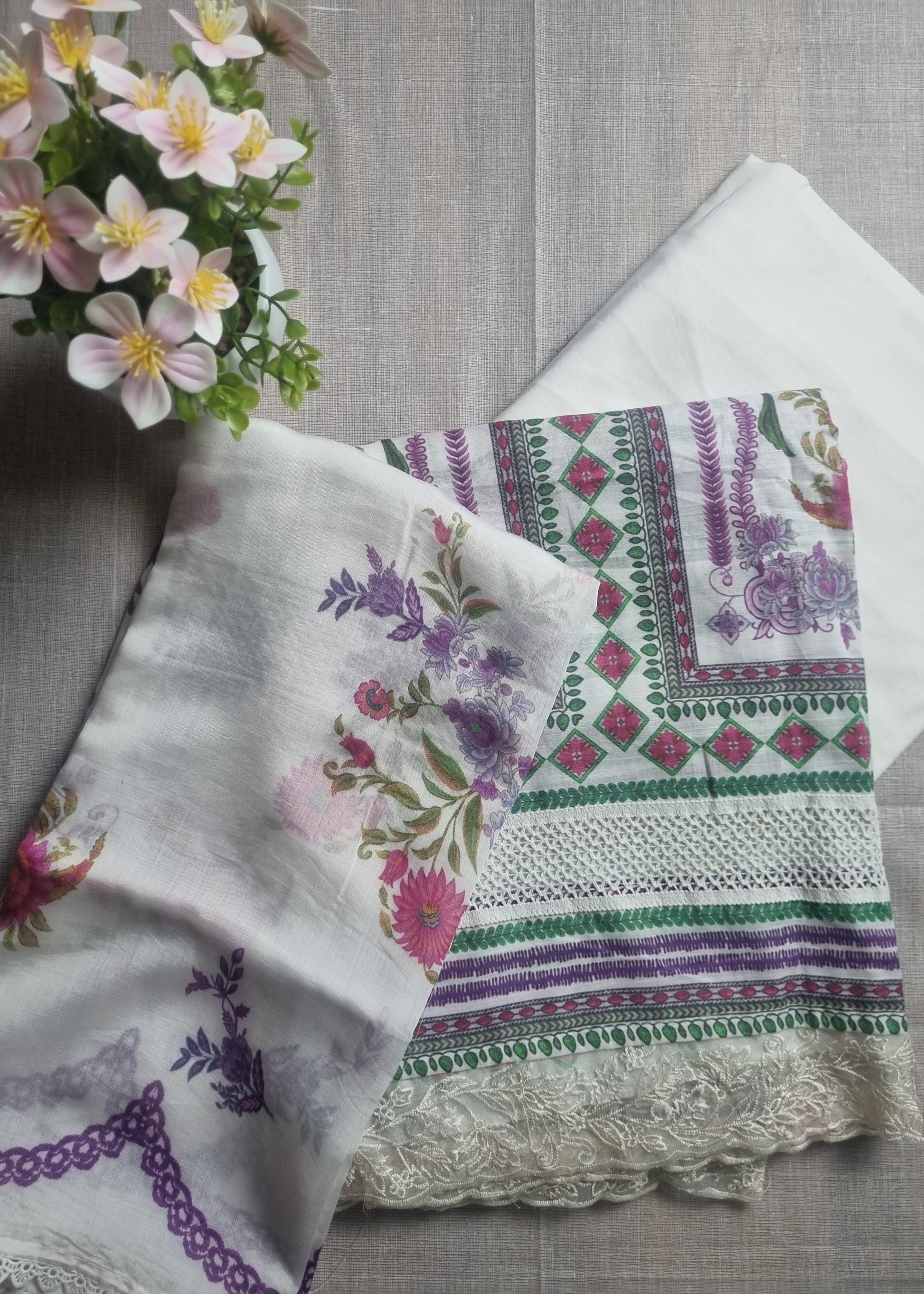 Set of embroidered fabric pieces on a wooden surface with flowers.