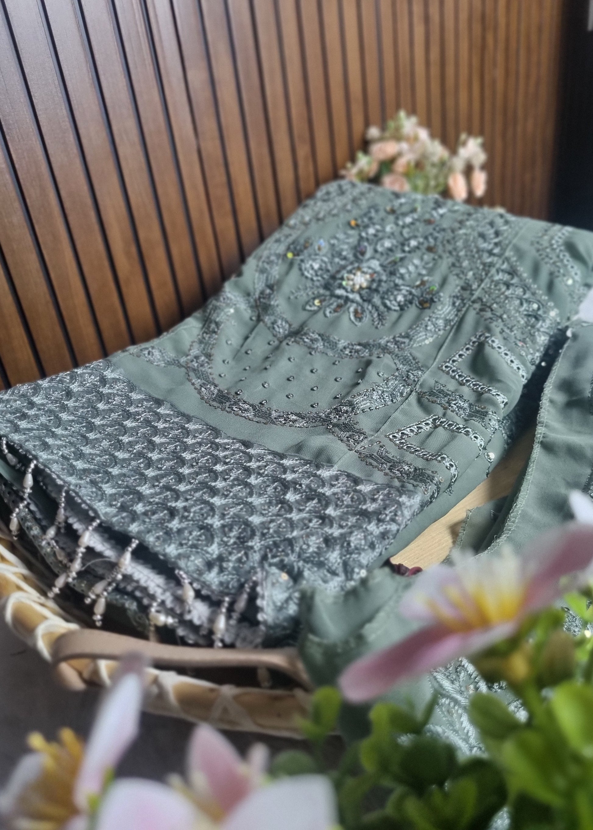 Green textured fabric with floral patterns on a wooden surface