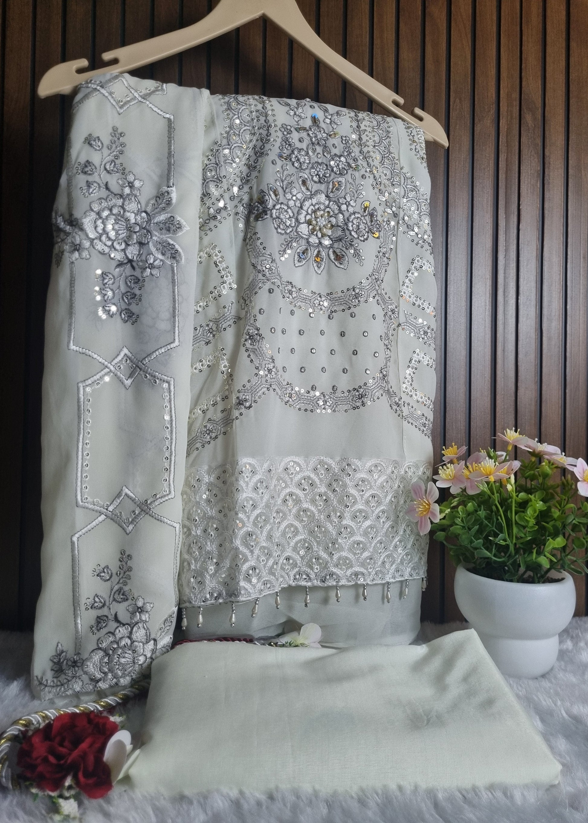 Decorative bedspread with floral patterns and embroidery on a wooden bed.