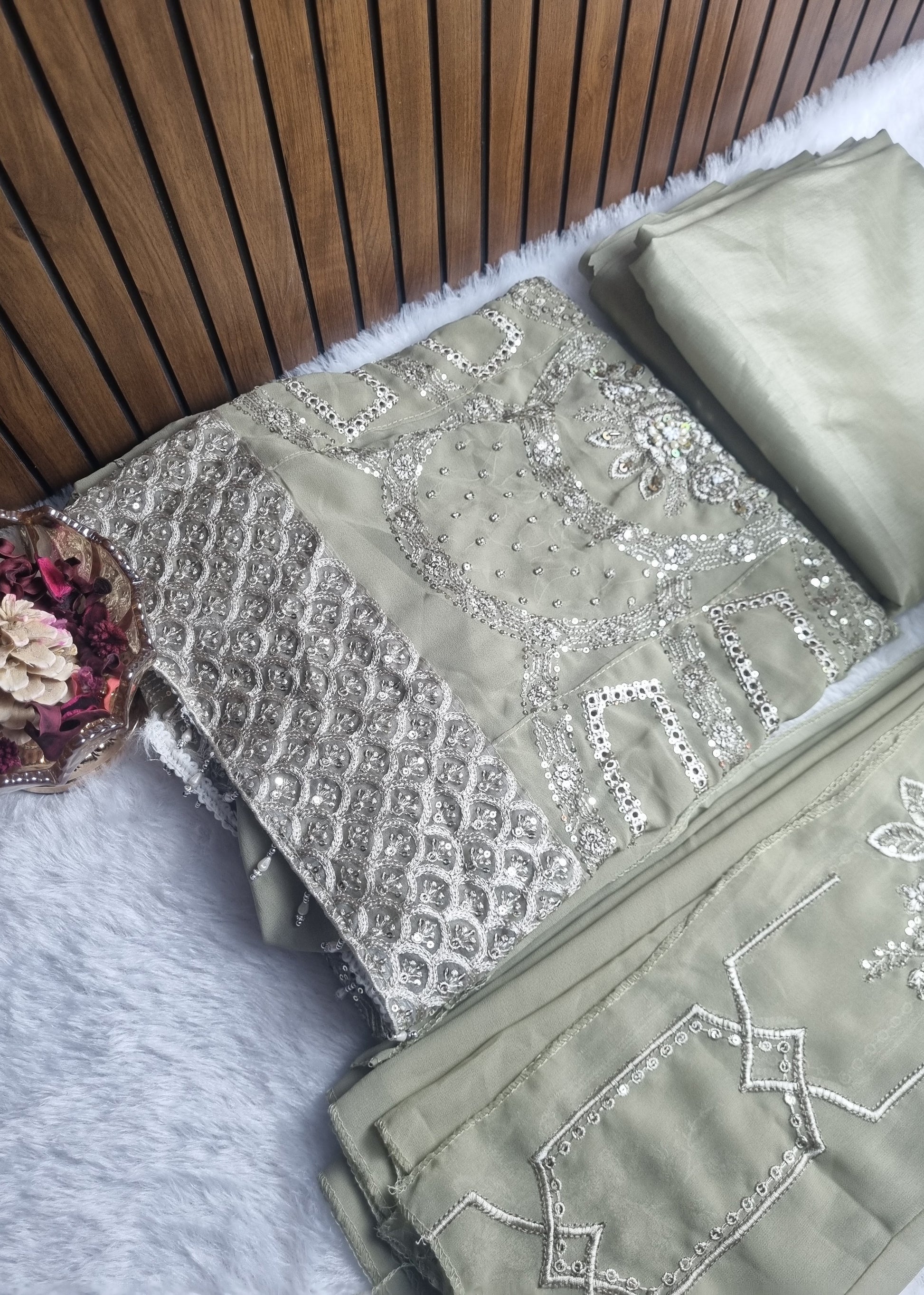 Embroidered fabric with silver thread on a wooden surface