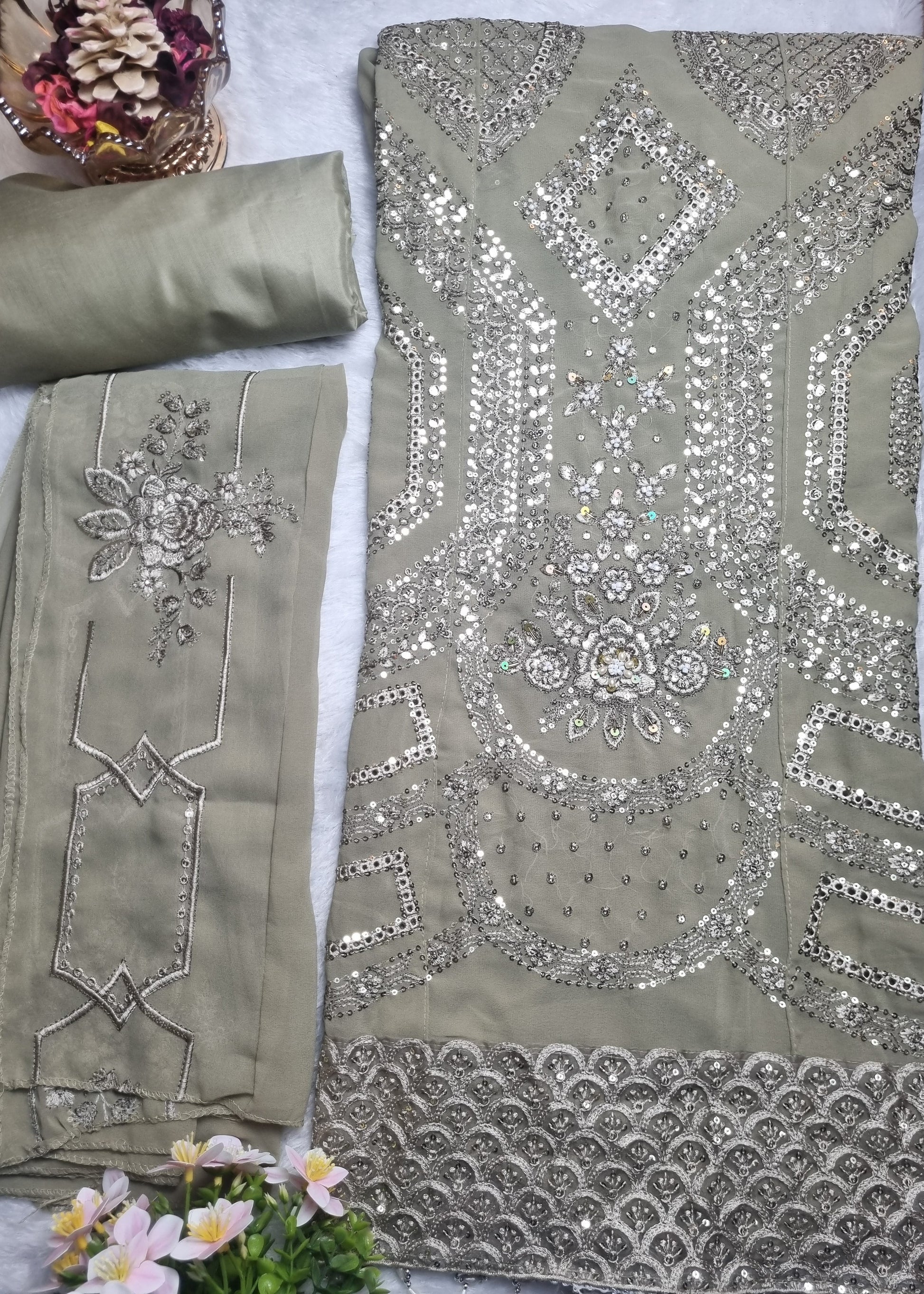 Decorative fabric with intricate patterns and embellishments on a plain background