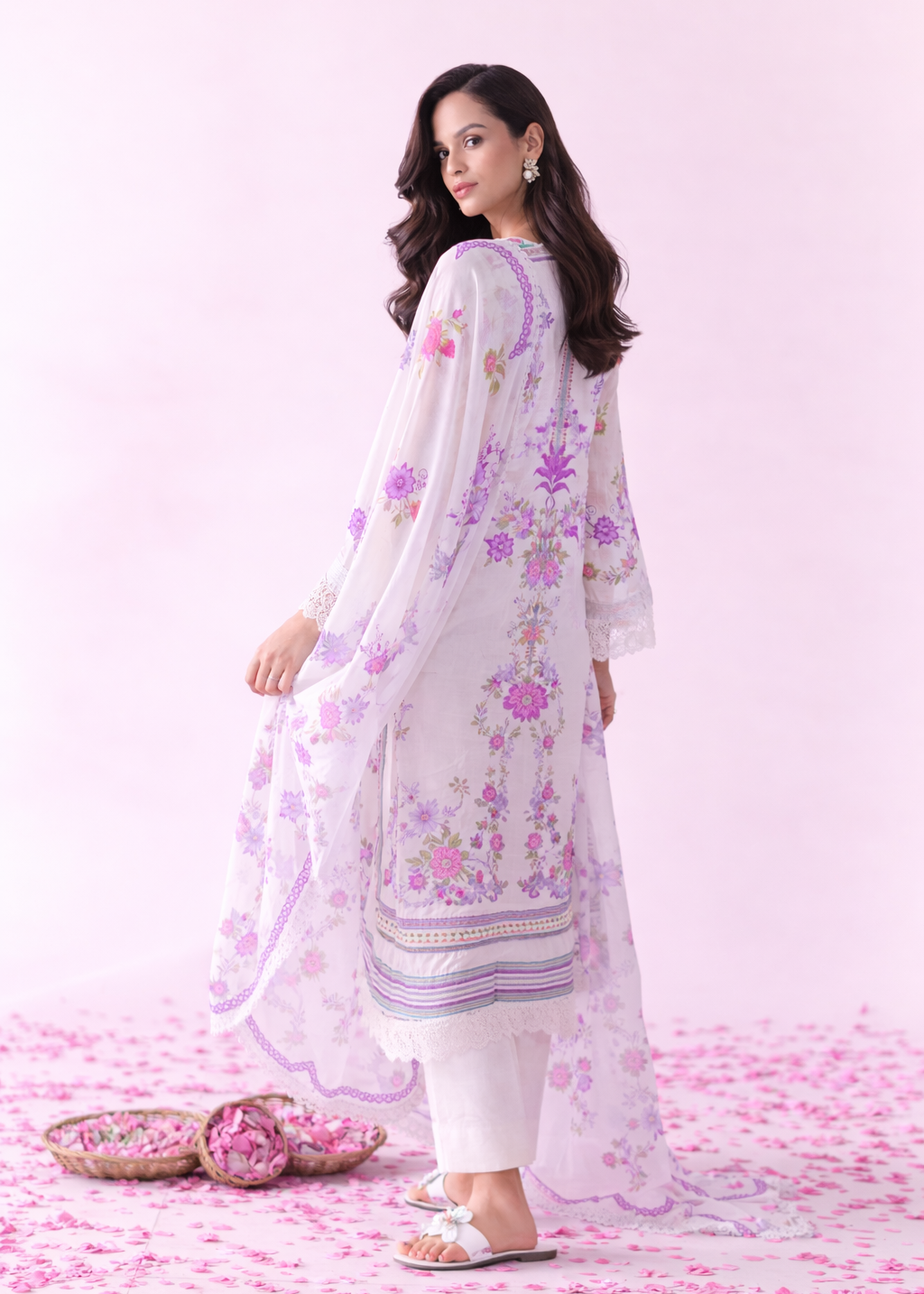 Woman wearing a white floral outfit on a pink floral background
