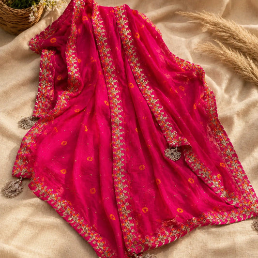 Fuchsia heritage Bandhani silk suit fabric with intricate motifs and elegant golden embellishments, festive ethnic wear