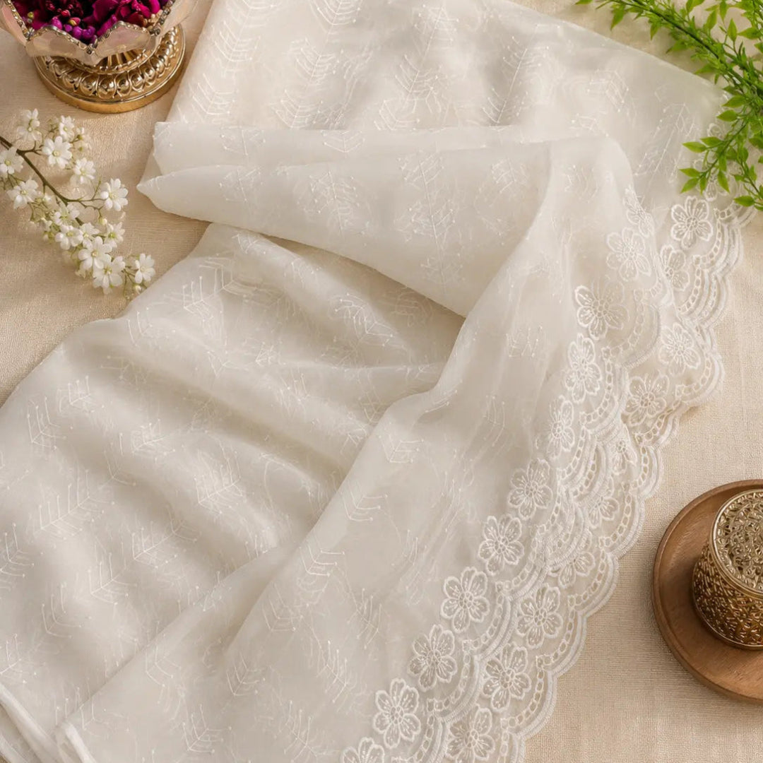 Pearl white Schiffli embroidered suit set with handcrafted embellishments, floral embroidery, golden accents and premium unstitched suit fabric for women by Nityashree
