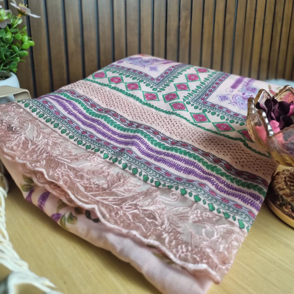 Decorative tablecloth with intricate patterns on a wooden surface.